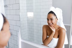 Belle jeune femme regardant sa réflexion dans le miroir photos libres de droits Belle jeune femme regardant sa réflexion dans le miroir photos libres de droits
