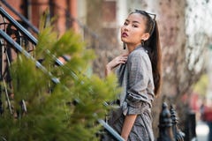 Belle jeune femme à la mode asiatique posant sur la rue de ville dehors photos libres de droits Belle jeune femme à la mode asiatique posant sur la rue de ville dehors photos libres de droits