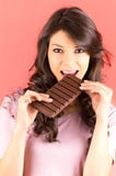 Belle jeune fille de brune mangeant du chocolat image stock Belle jeune fille de brune mangeant du chocolat image stock