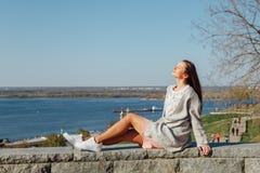 Belle jeune fille s'asseyant sur le remblai de la Volga photographie stock Belle jeune fille s'asseyant sur le remblai de la Volga photographie stock