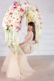 Belle jeune mariée dans une robe de mariage dans un intérieur chic dans un studio image stock Belle jeune mariée dans une robe de mariage dans un intérieur chic dans un studio image stock