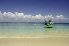 Belle plage tropicale à l'île de Kapas, Malaisie bateau de touristes ancré avec le fond de ciel bleu et le wate bleu clair comme images stock Belle plage tropicale à l'île de Kapas, Malaisie bateau de touristes ancré avec le fond de ciel bleu et le wate bleu clair comme images stock