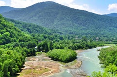 Belle viste delle montagne di Caucaso e di piccolo villaggio sulle banche del fiume Fotografie Stock Belle viste delle montagne di Caucaso e di piccolo villaggio sulle banche del fiume Fotografie Stock