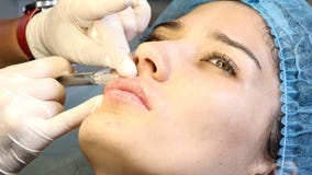 Bellezza moderna femminile Cosmetologia di Injectional L'estetista professionale femminile in guanti fa le iniezioni del riempito stock footage Bellezza moderna femminile Cosmetologia di Injectional L'estetista professionale femminile in guanti fa le iniezioni del riempito stock footage