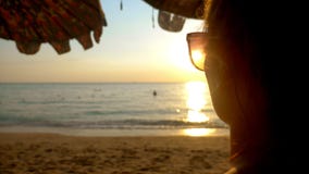Bello tramonto soleggiato sul mare Vista tramite gli occhiali da sole la donna in occhiali da sole esamina il tramonto sul mare stock footage Bello tramonto soleggiato sul mare Vista tramite gli occhiali da sole la donna in occhiali da sole esamina il tramonto sul mare stock footage