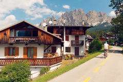 Beluno Italien-Augusti 9, 2018: Bergbyn av Cortina di Ampezzo turistcyklister fotografering för bildbyråer Beluno Italien-Augusti 9, 2018: Bergbyn av Cortina di Ampezzo turistcyklister fotografering för bildbyråer