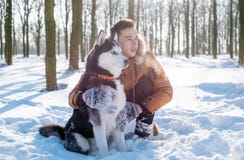 Bemannen Sie das Spielen mit Hund des sibirischen Huskys im schneebedeckten Park stockfoto Bemannen Sie das Spielen mit Hund des sibirischen Huskys im schneebedeckten Park stockfoto