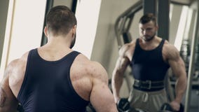 Bemannen Sie den Athleten, der zuhause seitliche Erhöhungen des Dummkopfs in der Turnhalle tut stock video Bemannen Sie den Athleten, der zuhause seitliche Erhöhungen des Dummkopfs in der Turnhalle tut stock video