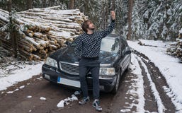 Bemannen Sie die Herstellung von selfie am Telefon nahe Auto im Winterwald stockfotos Bemannen Sie die Herstellung von selfie am Telefon nahe Auto im Winterwald stockfotos
