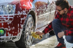 Bemannen Sie ` s Auto der Arbeitskraft waschende Leichtmetallräder auf einer Waschanlage lizenzfreie stockfotos Bemannen Sie ` s Auto der Arbeitskraft waschende Leichtmetallräder auf einer Waschanlage lizenzfreie stockfotos