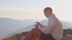 Bemannen Sie ` s Handtouch Screen der digitalen Tablette auf dem Hintergrund von Bergen stock video footage Bemannen Sie ` s Handtouch Screen der digitalen Tablette auf dem Hintergrund von Bergen stock video footage