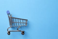 ben f?r bakgrundsp?sebegrepp som shoppar den vita kvinnan Shoppingvagn p? en bl? bakgrund arkivbild ben f?r bakgrundsp?sebegrepp som shoppar den vita kvinnan Shoppingvagn p? en bl? bakgrund arkivbild