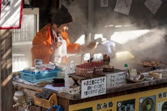 Beppu, Japão Vendedor da mulher que cozinha os ovos cozidos, alimento popular da rua em Beppu foto de stock royalty free Beppu, Japão Vendedor da mulher que cozinha os ovos cozidos, alimento popular da rua em Beppu foto de stock royalty free