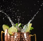 Ber?hmtes spritzendes alkoholisches Cocktail Moskau-Maultiers in den kupfernen Bechern stockfoto Ber?hmtes spritzendes alkoholisches Cocktail Moskau-Maultiers in den kupfernen Bechern stockfoto