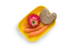 Bereitete liebevoll Lunchbox mit Mittagessenbrot, -apfel und -karotten auf weißem Hintergrund vor stockbild Bereitete liebevoll Lunchbox mit Mittagessenbrot, -apfel und -karotten auf weißem Hintergrund vor stockbild