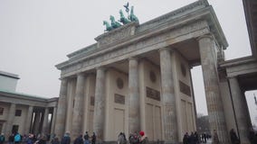 BERLÍN, ALEMANIA - 24 DE NOVIEMBRE DE 2018: Fotografían a los turistas contra el contexto de la puerta de Brandeburgo en Berlín almacen de video BERLÍN, ALEMANIA - 24 DE NOVIEMBRE DE 2018: Fotografían a los turistas contra el contexto de la puerta de Brandeburgo en Berlín almacen de video