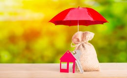 Beschermingsgeld en besparings bedrijfsconcept Het rode rode huis van de parapludekking met sleutel en zak van het ontslaan op gr royalty-vrije stock foto's Beschermingsgeld en besparings bedrijfsconcept Het rode rode huis van de parapludekking met sleutel en zak van het ontslaan op gr royalty-vrije stock foto's