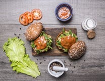 Bestandteile für das Kochen eines Burgers mit Huhn und Gemüse, Pfeffer, Tomaten, Kopfsalat und Salz auf hölzernem rustikalem Hint stockfoto Bestandteile für das Kochen eines Burgers mit Huhn und Gemüse, Pfeffer, Tomaten, Kopfsalat und Salz auf hölzernem rustikalem Hint stockfoto