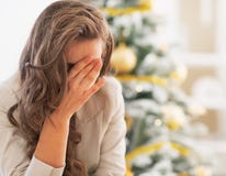 Betonte junge Frau vor Weihnachtsbaum lizenzfreies stockfoto Betonte junge Frau vor Weihnachtsbaum lizenzfreies stockfoto