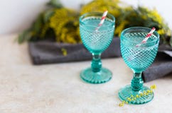 Bevanda di Refhesing in calici d'annata blu sui precedenti bianchi con i fiori srping fotografie stock Bevanda di Refhesing in calici d'annata blu sui precedenti bianchi con i fiori srping fotografie stock