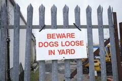 Beware dogs loose in yard sign on metal railing for security stock images Beware dogs loose in yard sign on metal railing for security stock images