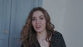 Bezauberndes junges Mädchen, das zur Kamera im modernen Innenraum aufwirft Sieherum mit Leidenschaft und Ausdruck spinnen und -b stock video footage Bezauberndes junges Mädchen, das zur Kamera im modernen Innenraum aufwirft Sieherum mit Leidenschaft und Ausdruck spinnen und -b stock video footage