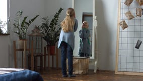 Beztroska mała dziewczynka robi śmiesznym twarzom w lustrze zbiory Beztroska mała dziewczynka robi śmiesznym twarzom w lustrze zbiory