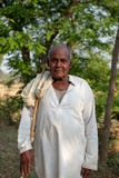 A man poses for a photo while herding cattle outside of Bhadarsa. stock image A man poses for a photo while herding cattle outside of Bhadarsa. stock image