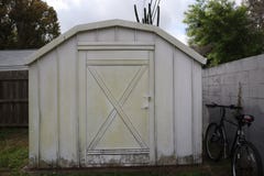 Biała podwórko jata bicykl przy ogrodzeniem zdjęcie stock Biała podwórko jata bicykl przy ogrodzeniem zdjęcie stock
