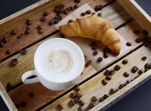 Biała filiżanka cappuccino i croissant na drewnianej tacy zdjęcie royalty free Biała filiżanka cappuccino i croissant na drewnianej tacy zdjęcie royalty free