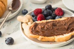 Biała filiżanka czarna herbata z croissant lub grzankami z masłem orzechowym, chokolate pastą, galaretą lub dżemem na białym drew zdjęcie stock Biała filiżanka czarna herbata z croissant lub grzankami z masłem orzechowym, chokolate pastą, galaretą lub dżemem na białym drew zdjęcie stock