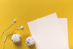 Białych księg prześcieradła na coloured backgroung z staczać się papierowymi i białymi słuchawkami zdjęcia royalty free Białych księg prześcieradła na coloured backgroung z staczać się papierowymi i białymi słuchawkami zdjęcia royalty free