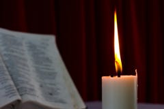 Biblia abierta en una tabla con la vela fotos de archivo Biblia abierta en una tabla con la vela fotos de archivo
