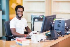 Bibliotecario de sexo masculino Working At Desk fotografía de archivo libre de regalías Bibliotecario de sexo masculino Working At Desk fotografía de archivo libre de regalías