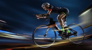 Bici atletica della strada di riciclaggio della donna nella sera fotografia stock Bici atletica della strada di riciclaggio della donna nella sera fotografia stock