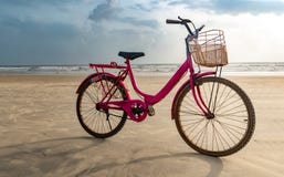 Bicicleta coloreada rosada de las señoras mayores parqueada en la playa después de completar un ciclo Una diversión llenó activid imagen de archivo libre de regalías Bicicleta coloreada rosada de las señoras mayores parqueada en la playa después de completar un ciclo Una diversión llenó activid imagen de archivo libre de regalías