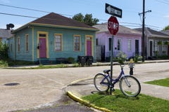 A bicicleta estacionou em um sinal da parada na frente de uma fileira de casas coloridas em uma rua da cidade de Nova Orleães em fotografia de stock royalty free A bicicleta estacionou em um sinal da parada na frente de uma fileira de casas coloridas em uma rua da cidade de Nova Orleães em fotografia de stock royalty free