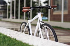 Bicicletta bianca dell'fisso-ingranaggio sulla via fotografie stock Bicicletta bianca dell'fisso-ingranaggio sulla via fotografie stock