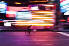 Bicycle Rider In Front Of US Flag At Times Square, NYC, In Motion Blur Royalty Free Stock Photography Bicycle Rider In Front Of US Flag At Times Square, NYC, In Motion Blur Royalty Free Stock Photography