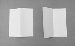 Bifold белая бумага шаблона на серой предпосылке Стоковое Изображение Bifold белая бумага шаблона на серой предпосылке Стоковое Изображение