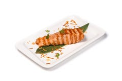 Bifteck de poissons rouge grillé sur une feuille en bambou dans un plat rectangulaire sur un fond blanc d'isolement image libre de droits Bifteck de poissons rouge grillé sur une feuille en bambou dans un plat rectangulaire sur un fond blanc d'isolement image libre de droits