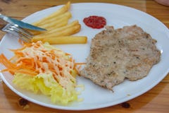 Bifteck de porc avec les pommes frites et la salade photo libre de droits Bifteck de porc avec les pommes frites et la salade photo libre de droits
