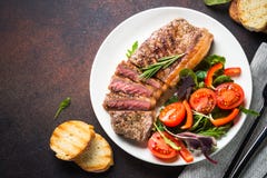 Bifteck grillé de striploin de boeuf avec la vue supérieure de salade fraîche photographie stock Bifteck grillé de striploin de boeuf avec la vue supérieure de salade fraîche photographie stock