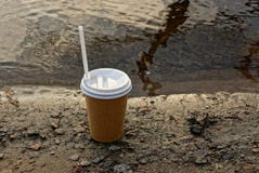 Paper glass with coffee on a wet ground near the water royalty free stock photo Paper glass with coffee on a wet ground near the water royalty free stock photo