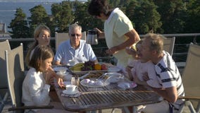 A big happy family has dinner on the open terrace on the roof of the house. stock video A big happy family has dinner on the open terrace on the roof of the house. stock video