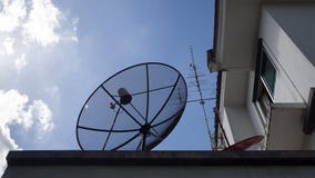 Big Satellite Dish, small red Satellite Dish and Antenna TV on the roof of house against with blue sky and white clouds royalty free stock images Big Satellite Dish, small red Satellite Dish and Antenna TV on the roof of house against with blue sky and white clouds royalty free stock images