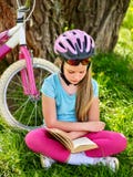 Bikes cycling girl wearing helmet read book on rest near bicycle. . Royalty Free Stock Image Bikes cycling girl wearing helmet read book on rest near bicycle. . Royalty Free Stock Image