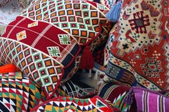 Bild av kulöra orientaliska kuddar och textilen med traditionell design arkivbild Bild av kulöra orientaliska kuddar och textilen med traditionell design arkivbild