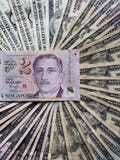 billete de banco singapurense de dos dólares y fondos con las cuentas de dólares americanas billete de banco singapurense de dos dólares y fondos con las cuentas de dólares americanas