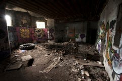 Binnen een verlaten concrete casemate van WO.II met graffiti en het skelet van een metaalbed op de Franse Atlantische kust stock afbeeldingen Binnen een verlaten concrete casemate van WO.II met graffiti en het skelet van een metaalbed op de Franse Atlantische kust stock afbeeldingen